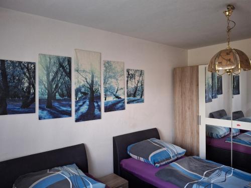 Habitación con 3 camas y pinturas en la pared. en Gute Laune, en Zapel
