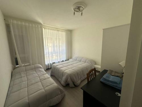 Un dormitorio con dos camas y un escritorio y una ventana. en CASA TITA PLAZA MAYOR a 1 minuto, 5 baños, en Salamanca