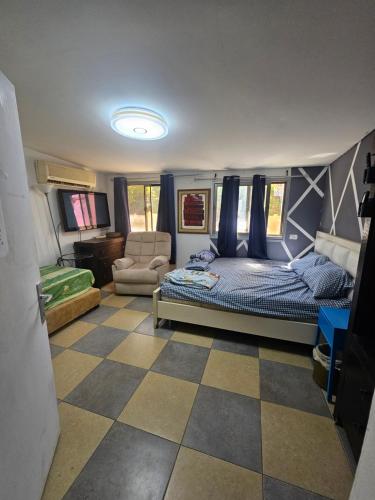 a bedroom with a bed and a couch in a room at בית קרקע לנופש עם חצר גדולה במרכז קרית שמונה in Qiryat Shemona