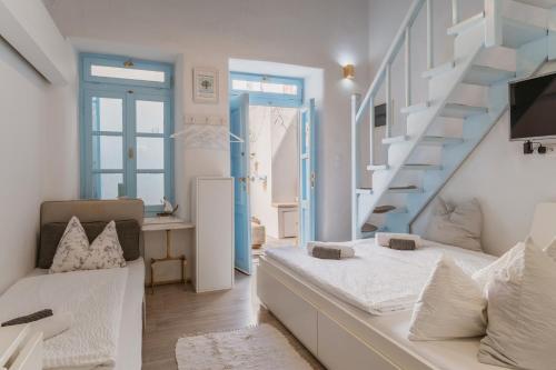 Habitación blanca con escalera y cama en 5-Bed Stylish Maisonette, en Mykonos ciudad