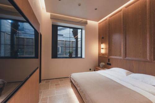 a bedroom with a large bed and two windows at PingYao Chengfu Jinyuan Hotel in Pingyao