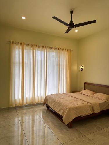 a bedroom with a bed and a ceiling fan at Vista valley in Kattappana