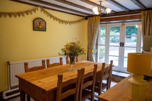 ein Esszimmer mit einem Holztisch und Stühlen in der Unterkunft Hill House 2 in Caton