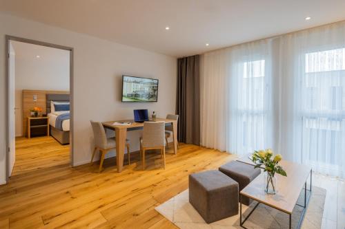 a living room with a table and a room with a bed at LMS - La Maison Suisse - Döttingen in Döttingen