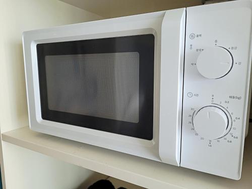 a white microwave oven sitting on a shelf at Busan Station KTX 30s Ocean View 부산역ktx 30초 오션뷰 in Busan