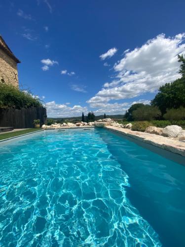 a swimming pool with blue water at Mas des Pelissiers Chambre & Table d'hote in Sabran