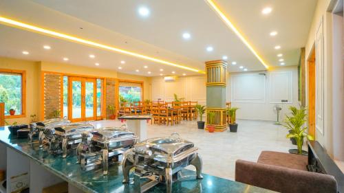 Zimmer mit einer Theke mit Tischen und Stühlen in der Unterkunft Corbett Mid Forest House - 1Min Walk to River & Jungle Safari in Rāmnagar