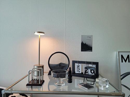 a glass table with a lamp and other items on it at Busan Station KTX 30s Ocean View 부산역ktx 30초 오션뷰 in Busan