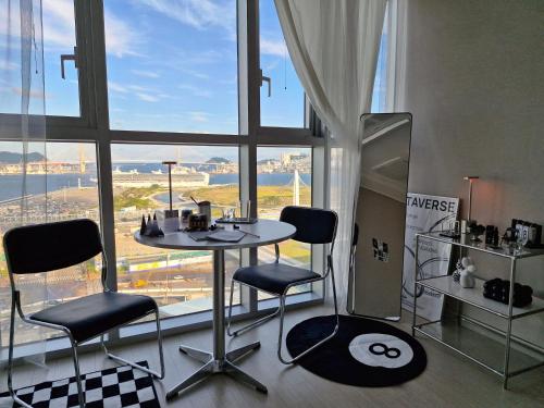 a table and chairs in a room with a large window at Busan Station KTX 30s Ocean View 부산역ktx 30초 오션뷰 in Busan