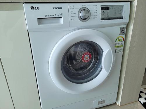 a white washing machine sitting in a room at Busan Station KTX 30s Ocean View 부산역ktx 30초 오션뷰 in Busan