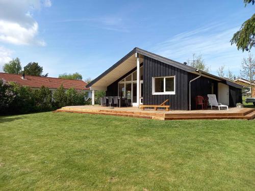 a small black house with a large yard at Sommerhus Ved Hvalpsund in Farsø