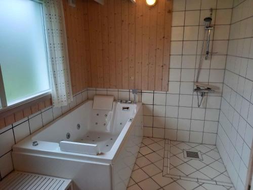a bathroom with a bath tub and a window at Sommerhus Ved Hvalpsund in Farsø