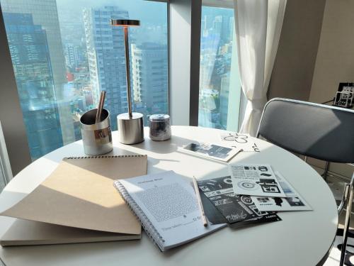 a white table with a laptop and a book on it at Busan Station KTX 30s Ocean View 부산역ktx 30초 오션뷰 in Busan