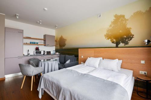 a bedroom with a large bed and a kitchen at Lettia Aparthotel in Jūrmala