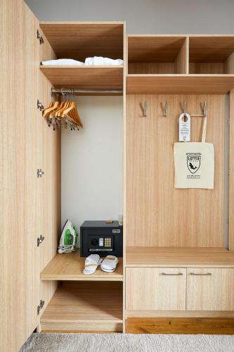 a closet with wooden shelves and a microwave at Lettia Aparthotel in Jūrmala