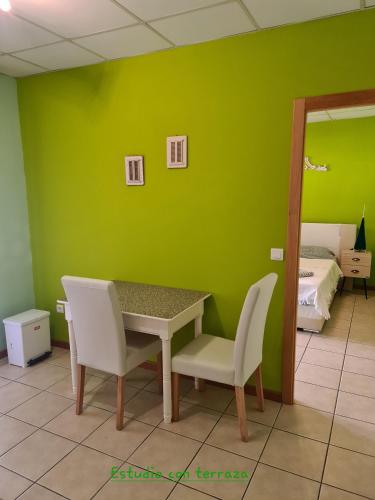 a green room with a table and two white chairs at Die kleine Auszeit in Denia