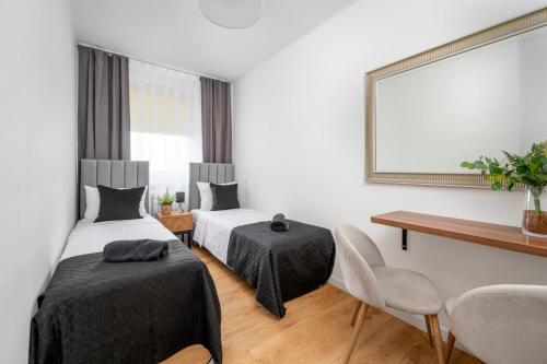 Un dormitorio con dos camas y un espejo. en Gliwicka Premium Apartament z balkonem, en Rybnik
