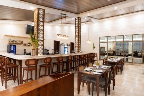 a restaurant with wooden tables and chairs and a bar at Treetop by Eight Continents, Zanzibar in Mchangani