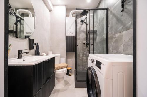 Un baño con lavabo y lavadora. en Gliwicka Premium Apartament z balkonem, en Rybnik