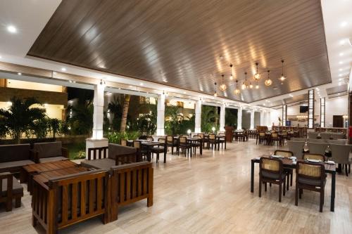 a restaurant with tables and chairs in a room at Treetop by Eight Continents, Zanzibar in Mchangani