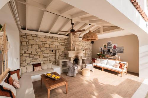 a living room with a fireplace and a stone wall at Viento Alacati Hotel in Alacati