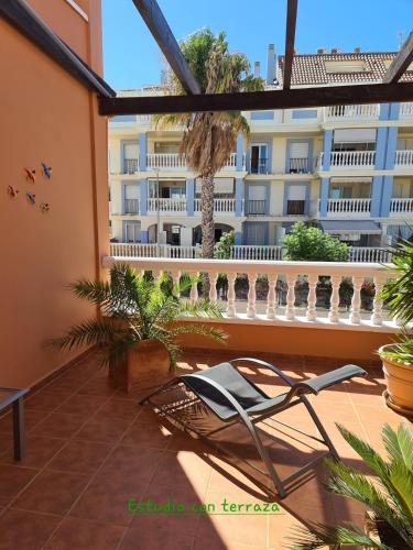 a balcony with a chair and a building at Die kleine Auszeit in Denia