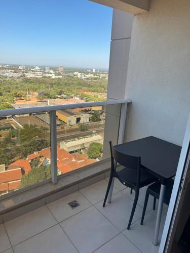 a black table and chair on a balcony with a view at FLAT ACONCHEGO, no centro, perto de tudo, linda vista! in Palmas