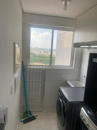 a bathroom with a window and a washing machine at FLAT ACONCHEGO, no centro, perto de tudo, linda vista! in Palmas