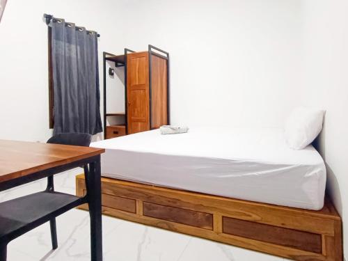 une chambre avec un lit, un bureau et une table dans l'établissement Ndalem Tamanan Syariah RedPartner, à Gondowulung