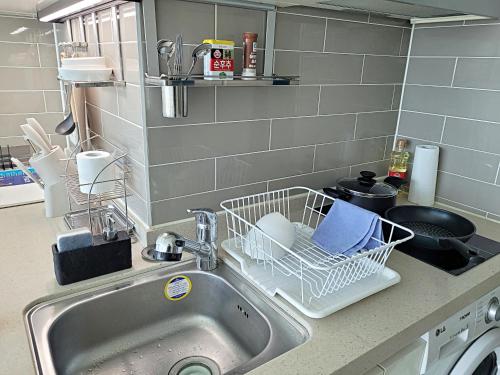 a kitchen sink with a dish drying rack on it at Busan Station KTX 30s Ocean View 부산역ktx 30초 오션뷰 in Busan