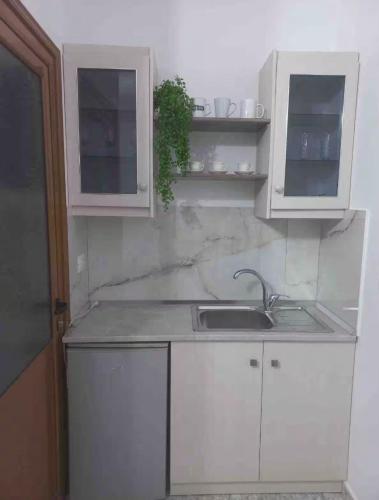 a kitchen with white cabinets and a sink at Kruti house in Përmet