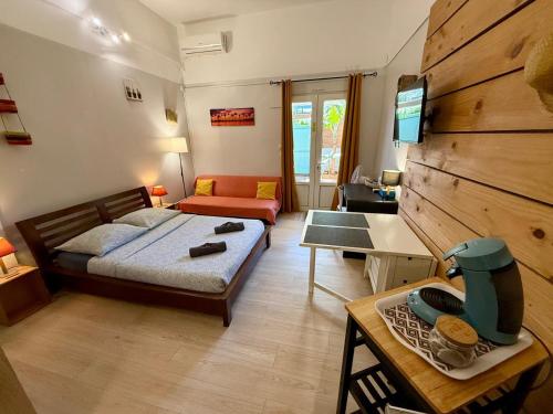 a room with a bed and a couch and a table at Les Cazes Terre Sainte 1 - Proche CHU in Saint-Pierre