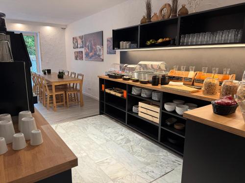 a kitchen with a counter and a table in it at Marias Inn - Bed & Breakfast in Garching bei München