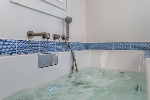 a bath tub filled with water with a hose at Milos Breeze Boutique Hotel in Pollonia