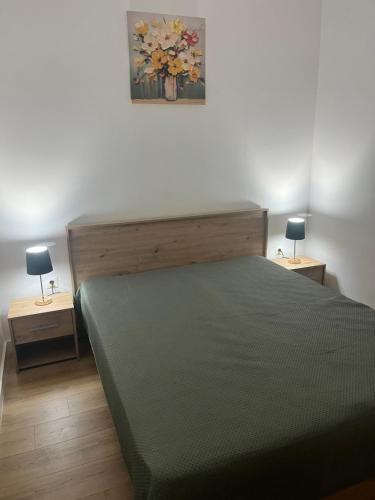 ein Schlafzimmer mit einem Bett und zwei Tischen mit Lampen in der Unterkunft White Palace in Palić