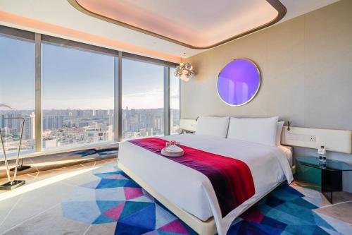 a bedroom with a large bed with a large window at W Suzhou - Jinji Lake in Suzhou