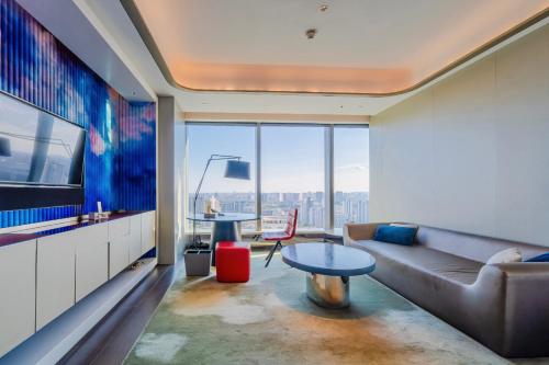 a living room with a couch and a tv at W Suzhou - Jinji Lake in Suzhou