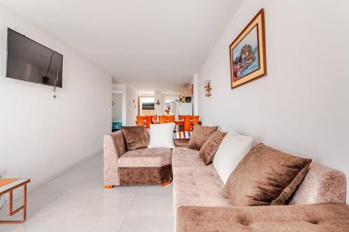 a living room with a couch and a tv at Stylish & Modern 2BR Apartment in Quito