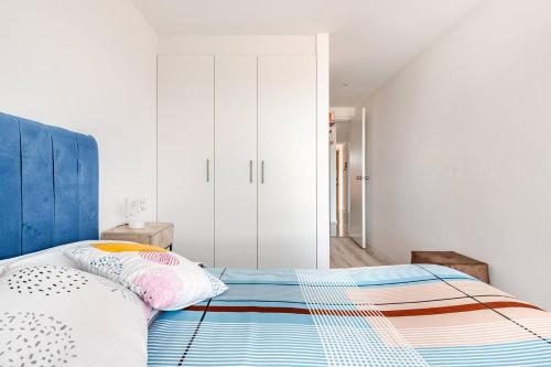 a bedroom with a bed with a blue headboard at Stylish & Modern 2BR Apartment in Quito