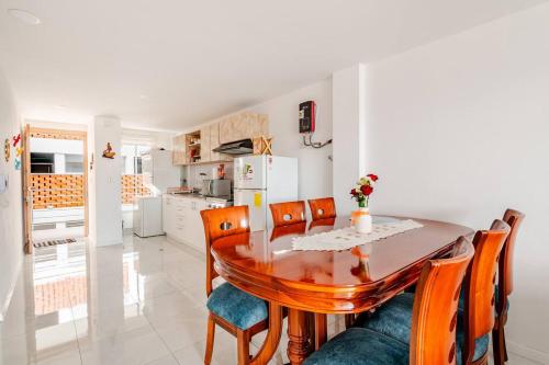 a kitchen and dining room with a wooden table and chairs at Stylish & Modern 2BR Apartment in Quito