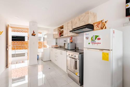 a kitchen with white appliances and a white refrigerator at Stylish & Modern 2BR Apartment in Quito