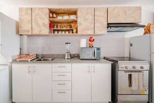 a kitchen with white cabinets and a counter top at Stylish & Modern 2BR Apartment in Quito