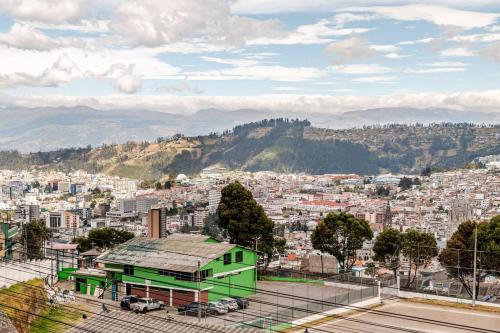 a view of a city with a green building at Stylish & Modern 2BR Apartment in Quito