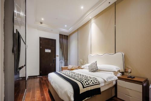 a hotel room with a large bed and a door at SEEU Designer Apartment in Shenzhen