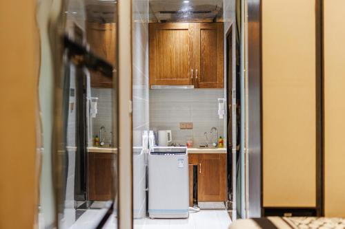 a kitchen with wooden cabinets and a refrigerator at SEEU Designer Apartment in Shenzhen