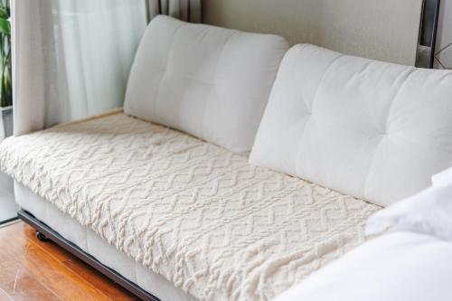 a white bed sitting next to a window at SEEU Designer Apartment in Shenzhen