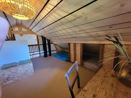 a room with a wooden ceiling and a table and a chair at L'Alpage, vue lac in Brison-Saint-Innocent