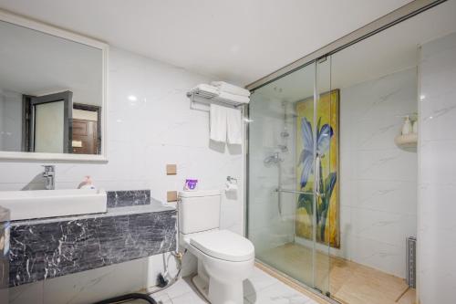 a bathroom with a shower and a toilet and a sink at SEEU Designer Apartment in Shenzhen