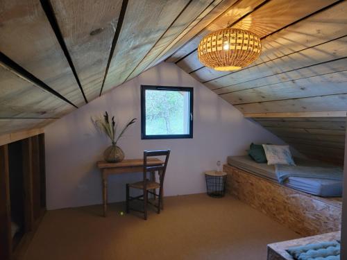 a room with a bed and a table and a lamp at L'Alpage, vue lac in Brison-Saint-Innocent