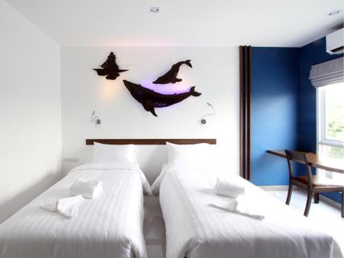 two beds in a room with bats on the wall at Anna-Nava Pakkret Hotel in Nonthaburi
